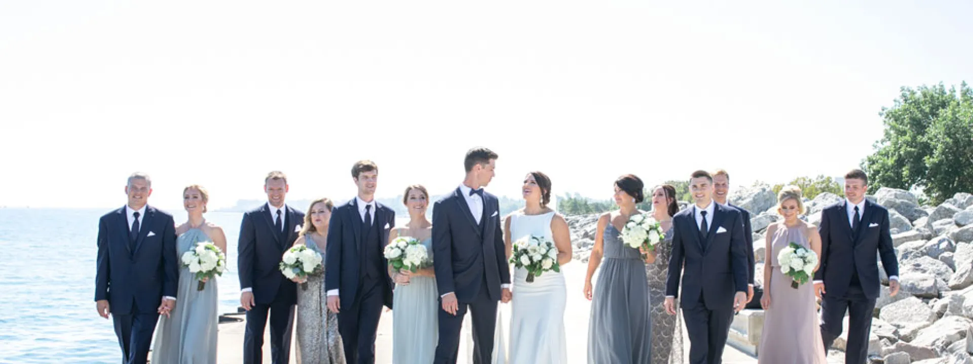 The bridal party stands along the water of Lake Michigan for their portraits