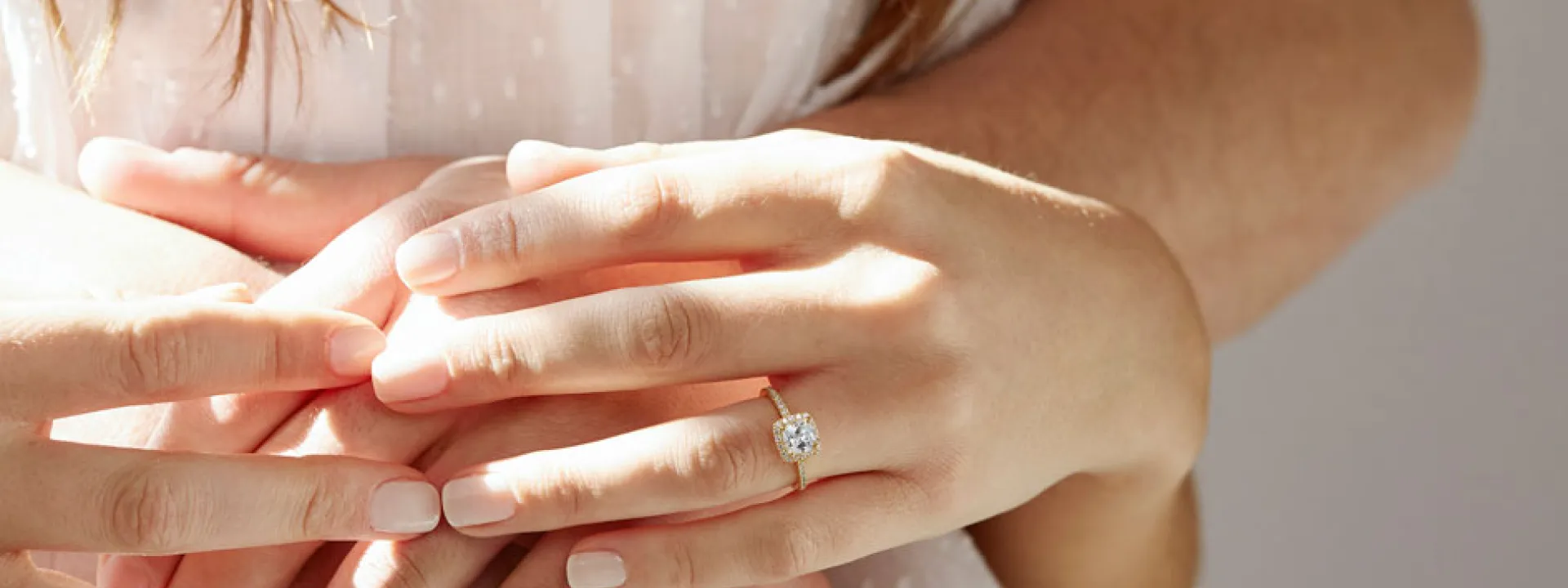 A couple holds hands; the bride wears a lab-grown halo ring